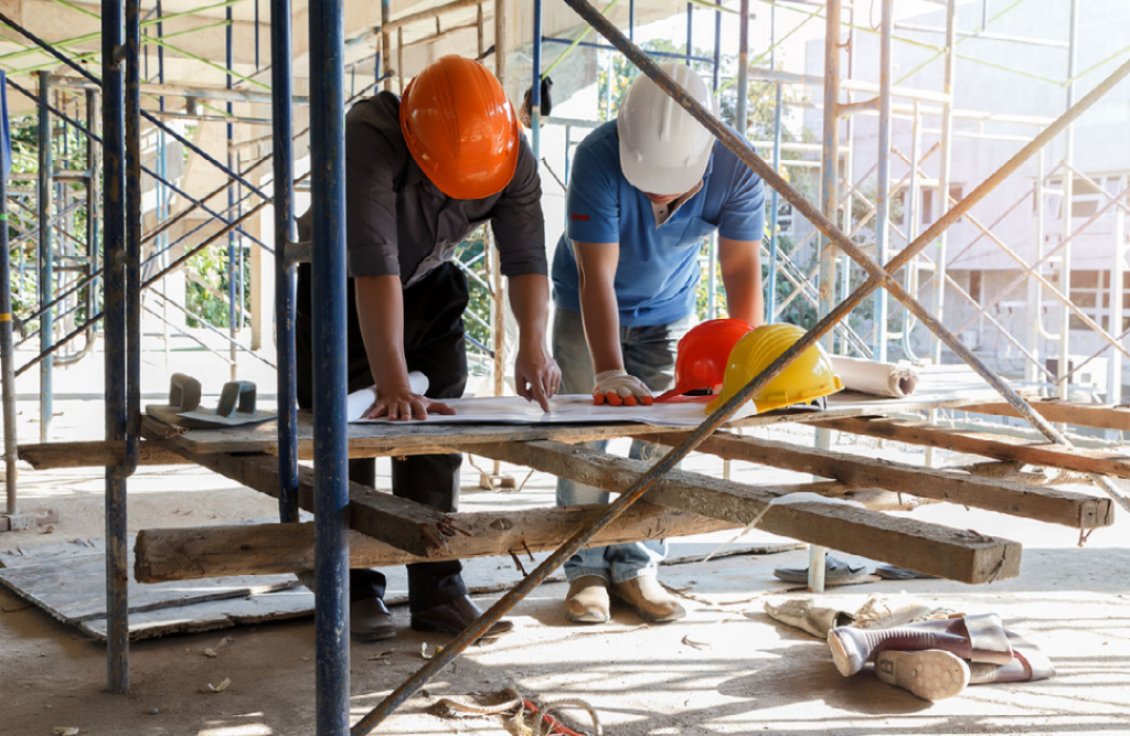 Image of Builders looking over blue prints on a job site