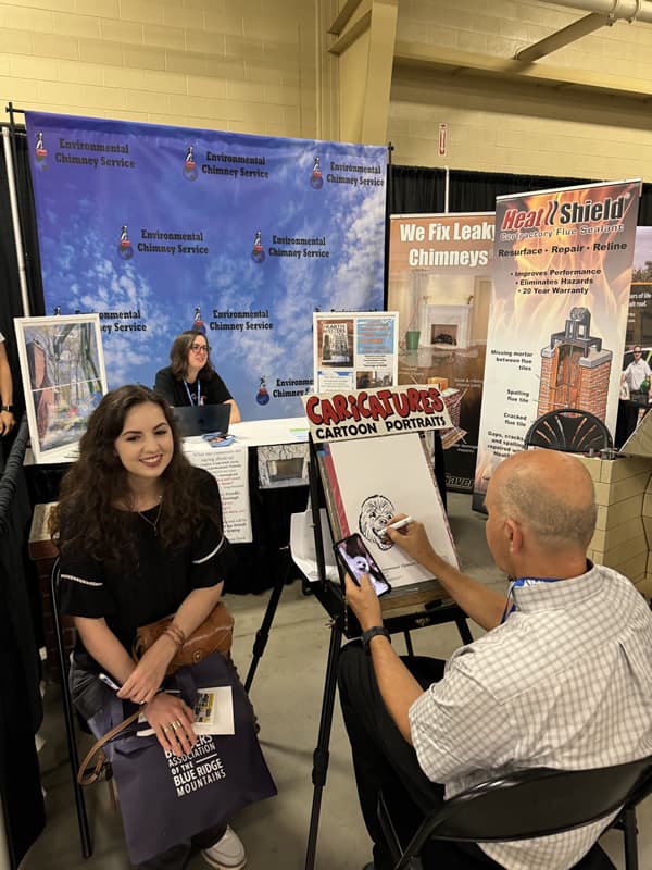Woman getting her caricature from male artist.