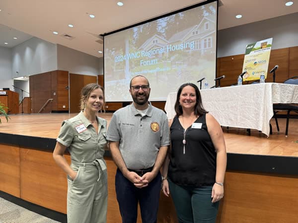 Sarah with a man and a woman at a conference.