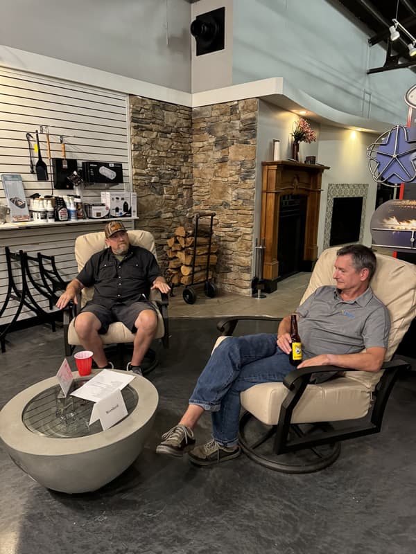 Two men sitting inside talking.