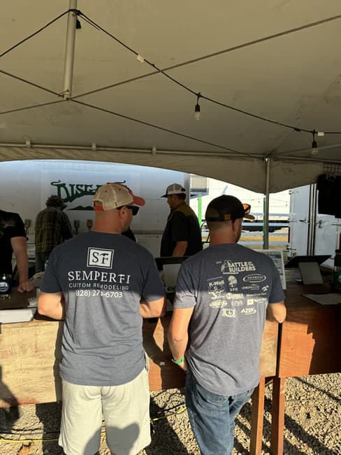 Shot of the back of two men with t-shirts and baseball caps.