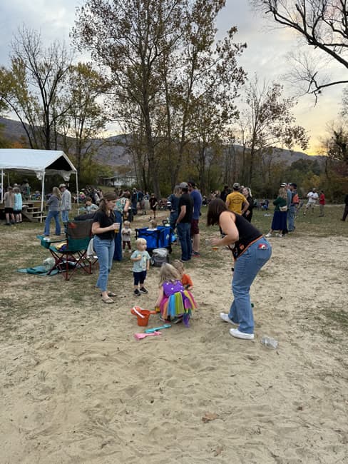 Children playing in the sand with parents.