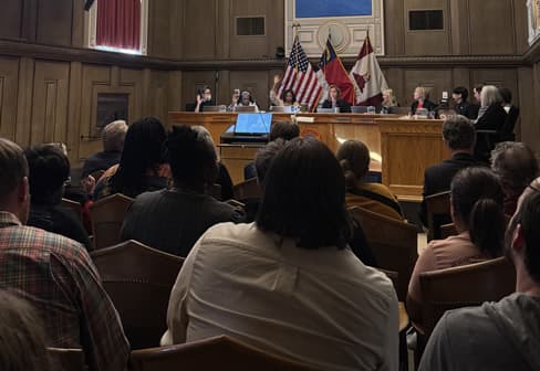 Crowd seated in front of city council listening