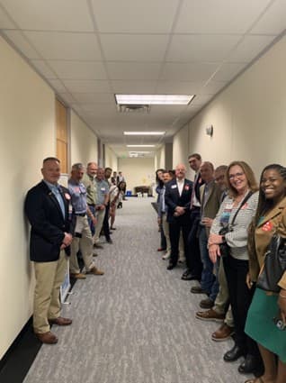 People lined up in hallway at NCHBA Q2 2025 meeting.
